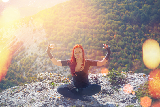 Frau meditiert auf Berg, Meditationsbegleitung