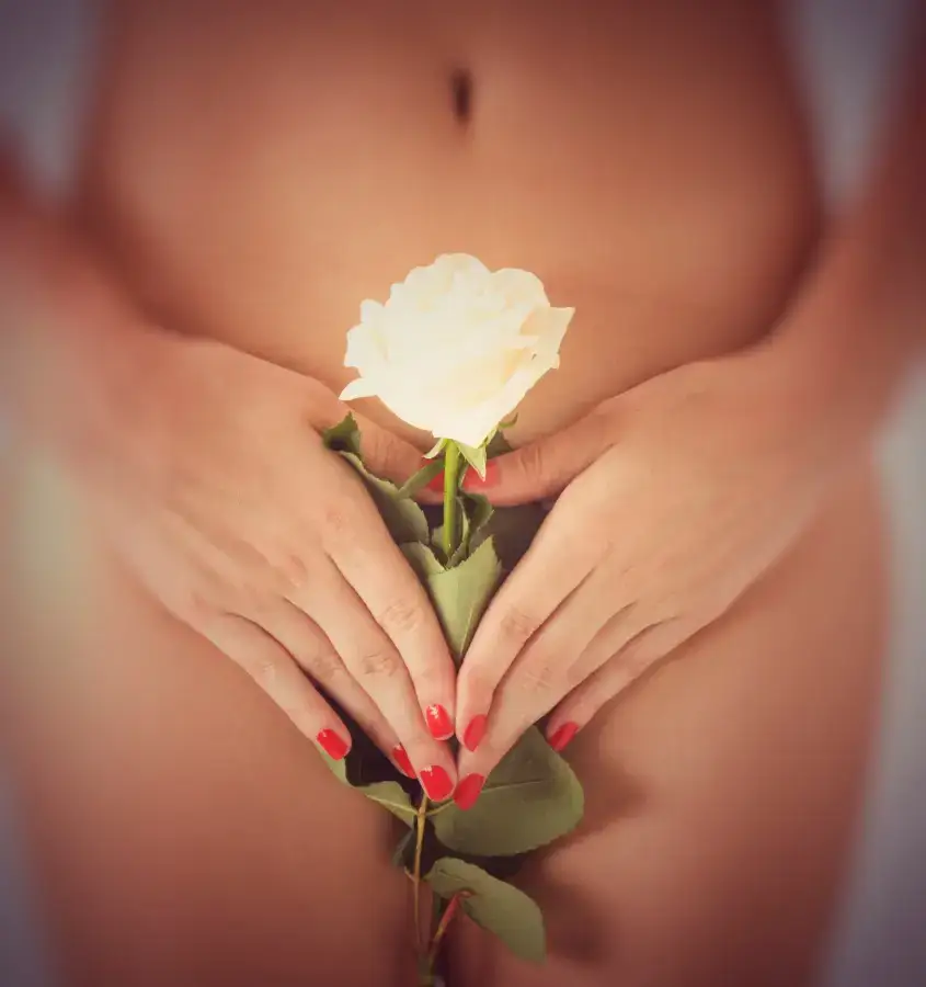 Eine nackte Person, die sich mit den Händen bedeckt, hält diskret eine weiße Rosenfrauenbegleitung.