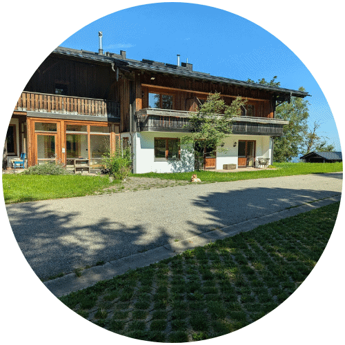 Zweistöckiges Holzhaus mit Balkon, perfekt für frauenbegleitung an einem sonnigen Tag.