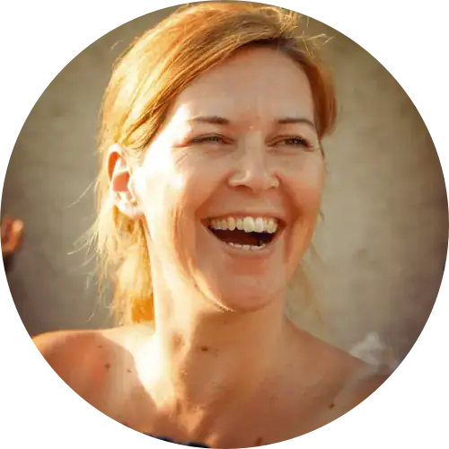 Frau mit hellbraunem Haar, lächelnd und lachend im hellen Sonnenlicht, genießt die Frauenbegleitung.