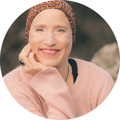 Lächelnde Frau in einem rosa Pullover und bedrucktem Kopftuch, die Frauenbegleitung verkörpert Wärme.