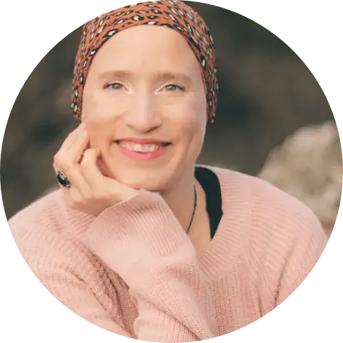 Lächelnde Frau in einem rosa Pullover und bedrucktem Kopftuch, die Frauenbegleitung verkörpert Wärme.